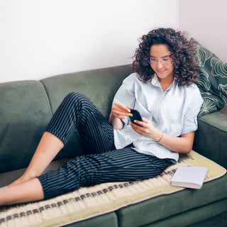 Woman relaxing on a sofa on the HealthyLine SOFT Pro mat