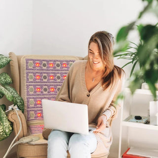 Woman with a laptop in an armchair fitted with the HealthyLine TAJ Chair mat
