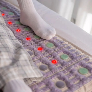 Foot resting on the HealthyLine TAJ mat on a bed