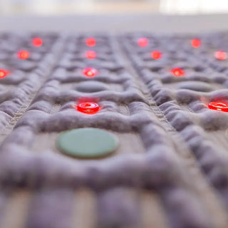 Close view of a jade stone and red lights on the HealthyLine TAJ mat