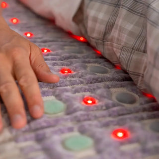 Hand on the HealthyLine TAJ mat with the red lights on
