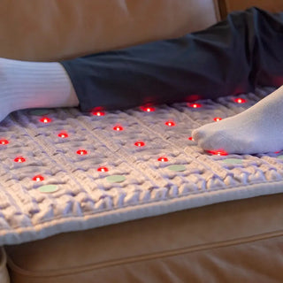 Feet resting on the HealthyLine TAJ mat on a leather sofa