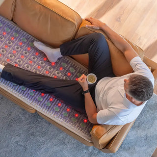Man with a coffee cup resting on the HealthyLine TAJ mat on a sofa