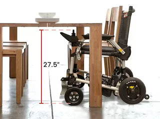 Journey Zoomer 09017 power chair pulled up under a wooden dining table, showing armrest clearance.