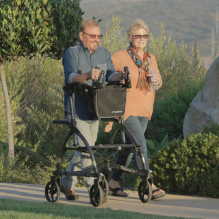A person walking upright inside a Journey UPWalker Original, forearms resting on the padded supports.