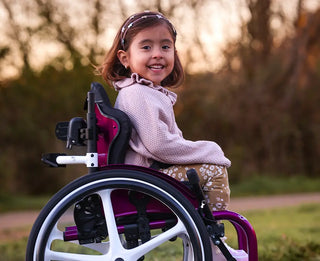 Ki Mobility Axiom Backs For Kids with a blurred natural background