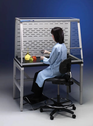 Person in a lab coat working at a Labconco 5 Feet Protector XVS Ventilation Station,32 Inch High, 115V or 230V, 50-60Hz, with Waste Chute with various items on the counter.