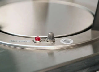 Lakeside 6409, Mobile Plate Dispenser, Heated, Four Stack, for 8-1/4 to 9-1/8 Inch Plates close-up of a pressure cooker lid with a red button and warning label.
