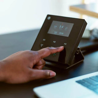 Hand interacting with a digital device on a desk