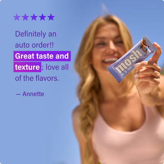 Customer holding a MOSH protein bar next to a written review