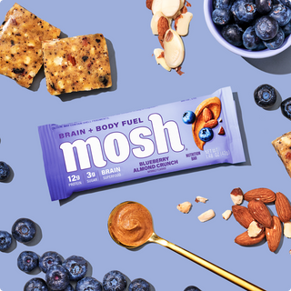 Wrapped MOSH Blueberry Almond Crunch Protein Bar surrounded by its flavor ingredients