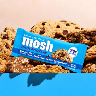 Wrapped MOSH Oatmeal Chocolate Chip High Protein Bar in front of oatmeal chocolate chip cookies
