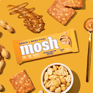 Wrapped MOSH Peanut Butter Crunch Protein Bar surrounded by its flavor ingredients