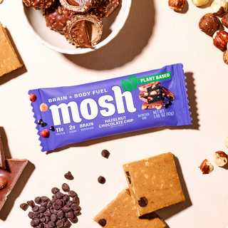 Wrapped MOSH Hazelnut Chocolate Chip Plant-Based Protein Bar surrounded by its flavor ingredients