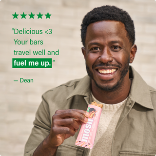 Customer holding a MOSH protein bar next to a written review