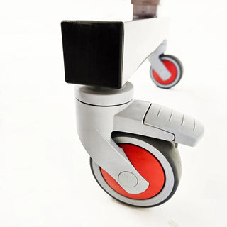 Close-up of a caster wheel with red tire and black cover on a white background