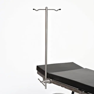 Medical operating table with an overhead MidCentral MCM-215 Rigid IV Pole on a white background