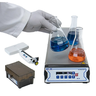 Laboratory setting with beakers, a Oxford BenchMate MHS-10 Multi-Position Magnetic Hotplate Stirrer and a gloved hand holding a beaker.
