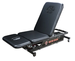 Black adjustable Pivotal Health THERA-P™ Electric Treatment Table with 'Boston College' branding on a white background