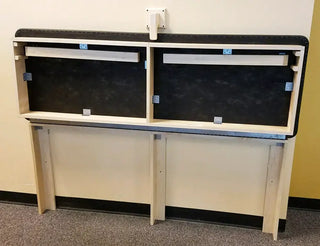 Pivotal Health Wall Mount Folding Treatment Table folded against a wall.