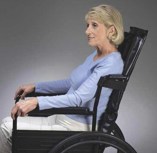 Woman sitting in a wheelchair against a gray background