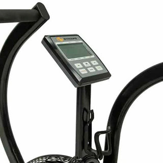 The Stroops AIRBIKE is a commercial fan exercise bike featuring a black steel frame, oversized front air resistance fan, moving upper-body handlebars, adjustable padded seat, foot pedals, and a wireless digital performance display mounted above the fan. Integrated transport wheels allow the bike to be moved easily while maintaining a heavy-duty commercial construction suitable for gyms, rehabilitation clinics, and performance training facilities.