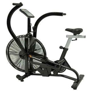 The Stroops AIRBIKE is a commercial fan exercise bike featuring a black steel frame, oversized front air resistance fan, moving upper-body handlebars, adjustable padded seat, foot pedals, and a wireless digital performance display mounted above the fan. Integrated transport wheels allow the bike to be moved easily while maintaining a heavy-duty commercial construction suitable for gyms, rehabilitation clinics, and performance training facilities.