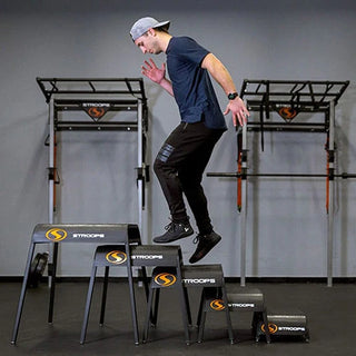 Stroops Ergo Plyo Boxes are black stackable plyometric training boxes with rounded edges, smooth ski-like legs, and non-slip top surfaces, available in five heights from 6 to 30 inches.