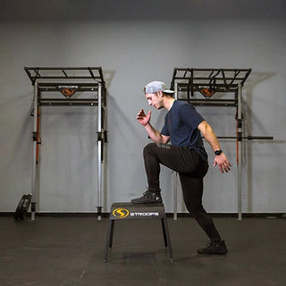 Stroops Ergo Plyo Boxes are black stackable plyometric training boxes with rounded edges, smooth ski-like legs, and non-slip top surfaces, available in five heights from 6 to 30 inches.