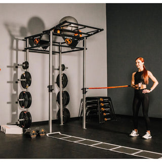 The Stroops FSPR Performance Rack is a sleek, low-profile black fitness station with a sturdy rack structure, adjustable J-hooks for Olympic barbells, four resistance band anchor points, and upper storage space for workout equipment. The station is designed for resistance and power training and can accommodate up to two users.