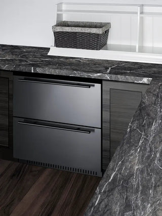Summit SPR275OS2DADA built-in outdoor refrigerator drawers installed beneath a stone countertop. The stainless steel dual-drawer refrigeration unit is seamlessly integrated into outdoor cabinetry, providing convenient cold storage for beverages and food while maintaining a modern outdoor kitchen design.