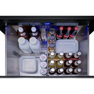 Top-down view of the Summit SPR275OS2DPNRADA outdoor refrigerator drawer filled with beverage bottles, soft drinks, food containers, and organized storage compartments inside a stainless steel refrigerated drawer system.