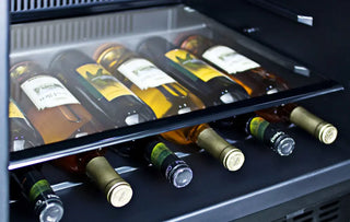 Close-up view of wine bottles stored horizontally in the sliding storage drawer of the Summit SPR627OSCSS outdoor refrigerator.