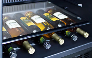 Close-up view of wine bottles stored horizontally on the integrated wine storage shelf inside the Summit SPR627OS outdoor refrigerator.
