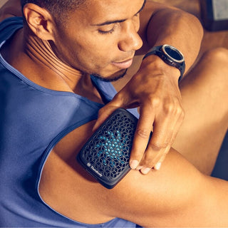 Man wearing the Therabody RecoveryTherm Cube strapped to his upper arm
