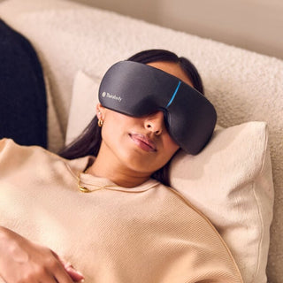 Woman lying down wearing the Therabody SmartGoggles eye massager