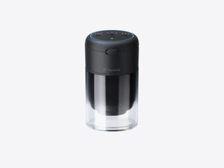 Therabody TheraCup cupping device standing upright with a transparent cup fitted