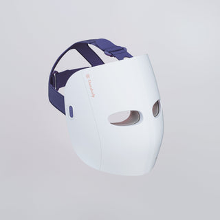 Angled view of the Therabody TheraFace Mask Glo showing its padded adjustable head strap