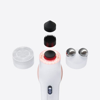 Therabody TheraFace PRO shown with its attachments laid out around it and the light ring glowing red