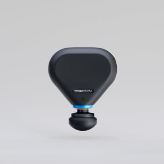 Therabody Theragun Mini Plus massage gun standing upright on a plain background