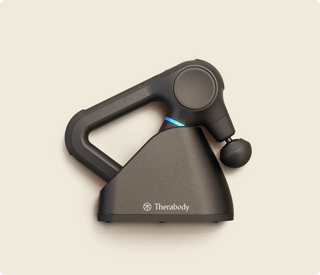 Therabody Theragun Prime Charging Stand holding a Theragun Prime, which is sold separately