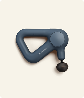 Flat studio view of the navy Therabody Theragun Relief with a ball attachment fitted