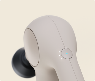 Close-up of the head and power button on the sand coloured Therabody Theragun Relief