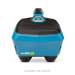 Thumper Lithium2 cordless percussion massager in black and teal with rechargeable battery and charging nest.