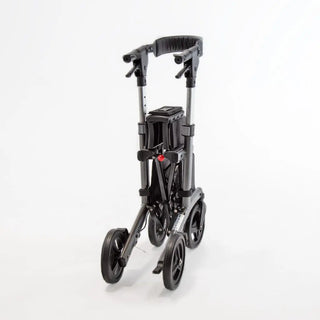 Compact Triumph Mobility Escape Petite rollator with a lightweight aluminum frame, padded seat, adjustable padded backrest, anatomical handgrips, four wheels, and a folding shopping bag beneath the seat.
