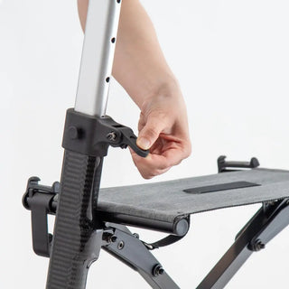 Black carbon fibre Triumph Mobility Maverick rollator walker with a padded seat, backstrap, ergonomic handgrips, integrated shopping bag, cup holder, cane holder, and large front wheels.