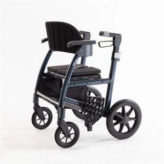 Light blue Triumph Prestige all-in-one rollator and transport chair with a black padded seat, padded backrest, ergonomic handgrips, armrests, four wheels, and integrated footrests in transport chair configuration.