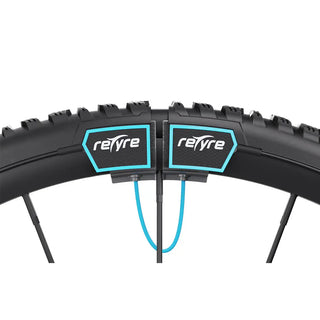 Pair of black reTyre Traction Skins attached over wheelchair tires with rugged tread and Velcro fasteners for improved traction on snow, slush, rain, grass, and gravel.