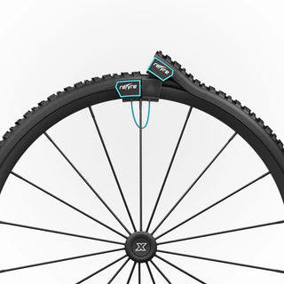 Pair of black reTyre Traction Skins attached over wheelchair tires with rugged tread and Velcro fasteners for improved traction on snow, slush, rain, grass, and gravel.