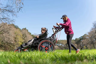 VIPAMAT Hippocampe Marathon wheelchair pushed by a woman across a grassy field